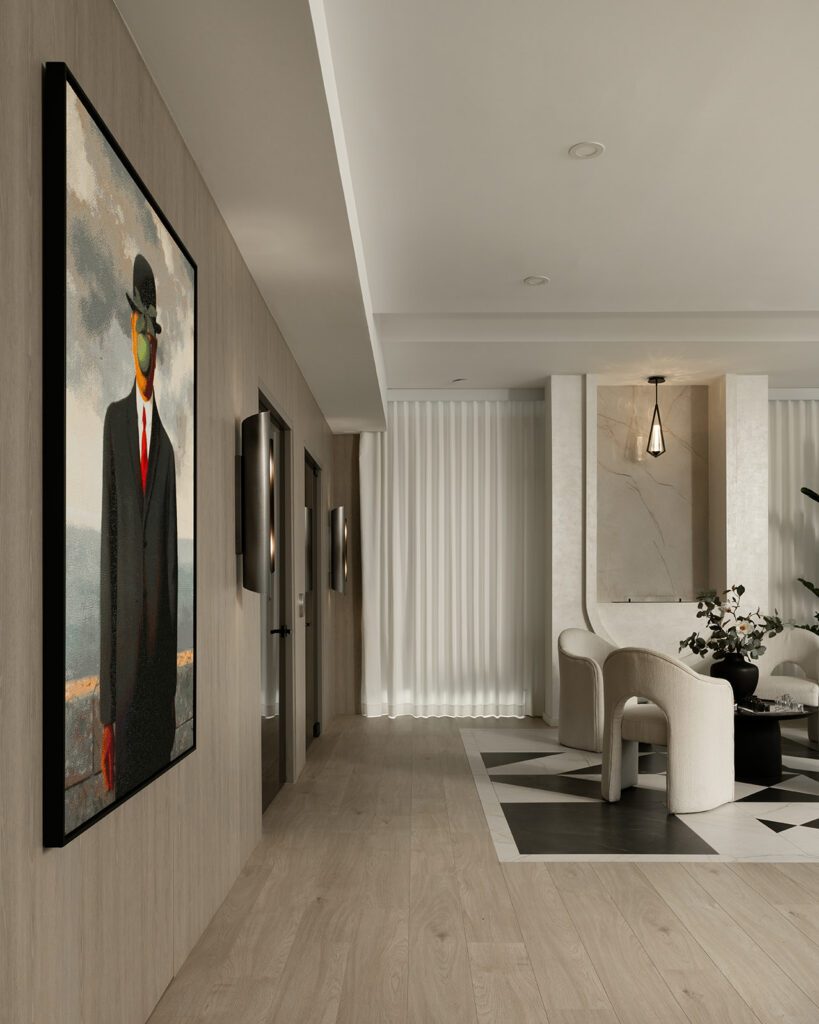 A open concept penthouse entry with smoked glass elevator doors, marble inlay to emphasize the seating area accentuated with an enthonol fireplace.